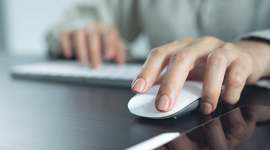 A woman using a mouse at the computer