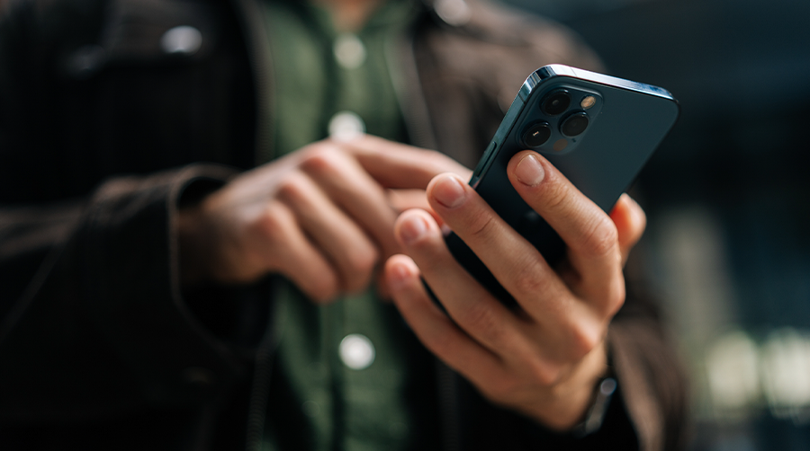 A man holding a cell phone, checking a text message