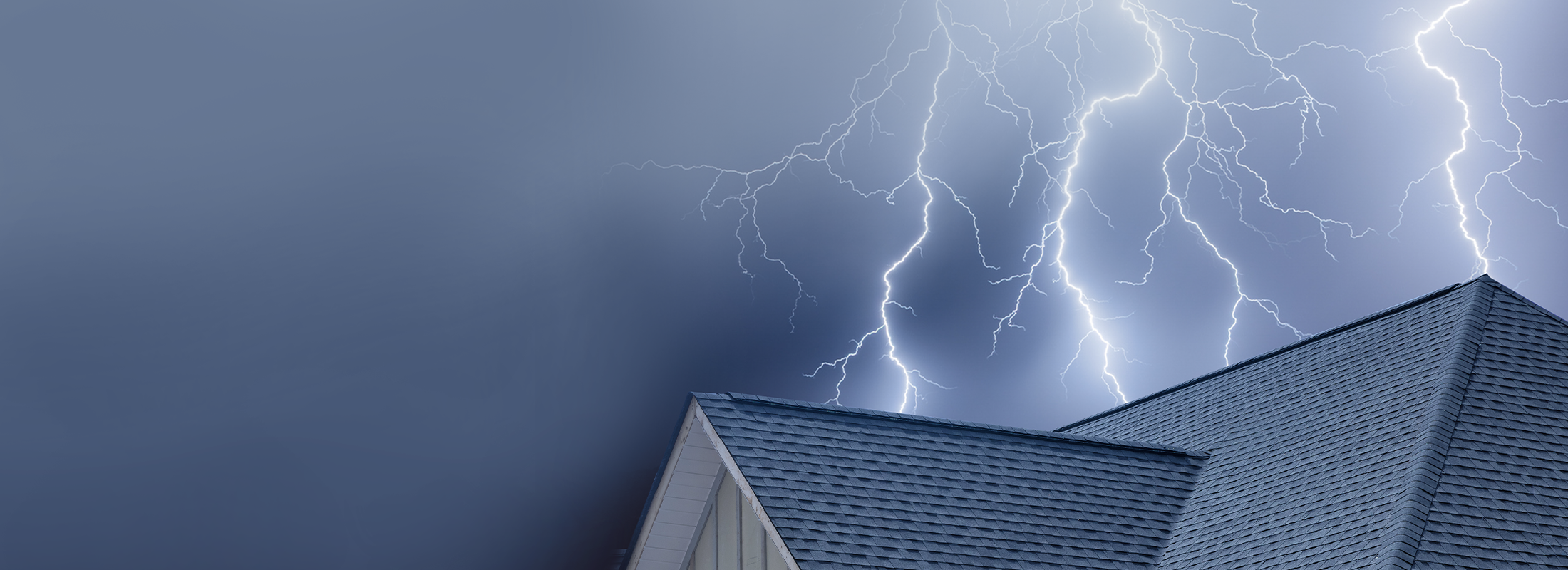 Shingle roof with lightning coming down in the background